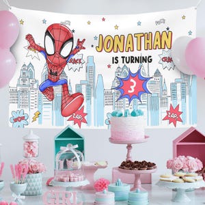 Puede incluir: Un tel&oacute;n de fondo rectangular blanco para fiestas con un personaje de Spider-Man de dibujos animados, una ilustraci&oacute;n de un horizonte urbano y el texto JONATHAN IS TURNING 3. Incluye globos de texto estilo c&oacute;mic con POW, CRACK y ZAP.