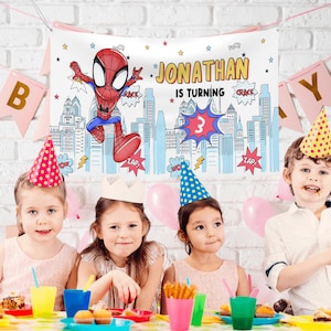 Puede incluir: Una pancarta rectangular de tela con un personaje de Spider-Man, una ilustraci&oacute;n de un horizonte urbano y el texto JONATHAN IS TURNING 3. El dise&ntilde;o incluye burbujas de di&aacute;logo estilo c&oacute;mic con las palabras POW, CRACK y ZAP.