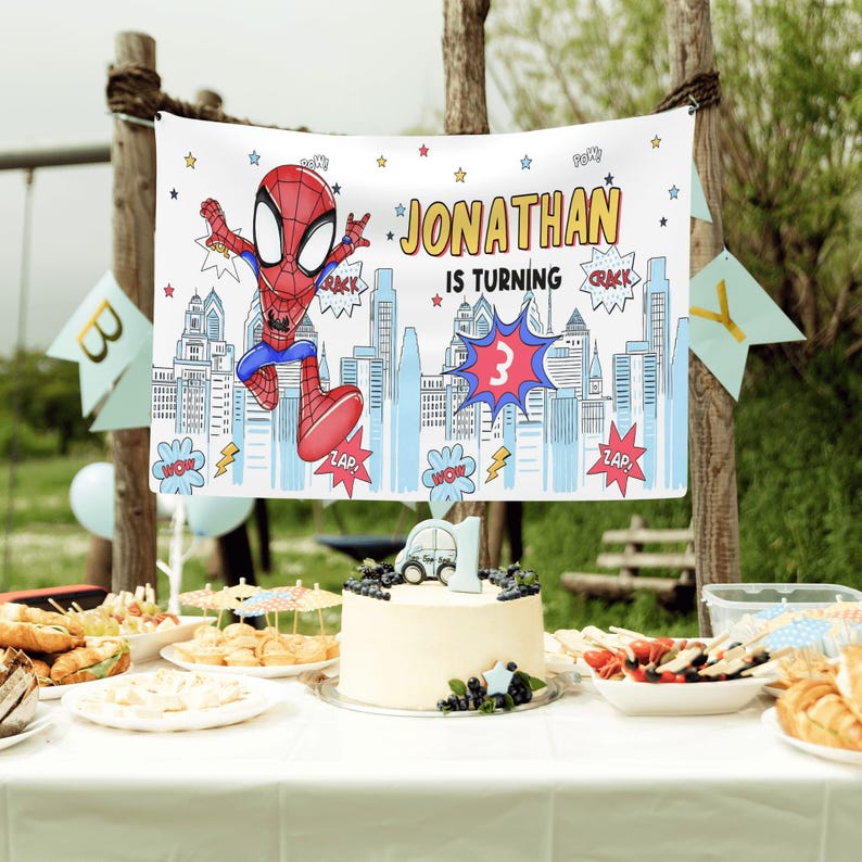 Puede incluir: Una pancarta de fiesta rectangular blanca con un personaje de Spider-Man rojo y azul, una ilustraci&oacute;n del horizonte de la ciudad y el texto JONATHAN IS TURNING 3. El dise&ntilde;o incluye globos de texto estilo c&oacute;mic con palabras como CRACK, WOW y ZAP.