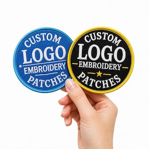 Könnte beinhalten: Zwei kreisförmige gestickte Aufnäher mit dem weißen Text CUSTOM LOGO EMBROIDERY PATCHES. Ein Aufnäher hat einen blauen Hintergrund mit blauem Rand, der andere einen schwarzen Hintergrund mit gelbem Rand und einem kleinen gelben Stern.