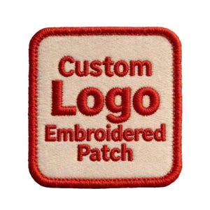 May include: A square embroidered patch with rounded corners featuring a cream-colored background and a thick red border. The text Custom Logo Embroidered Patch is stitched in red thread in the center of the patch in a bold, sans-serif font.