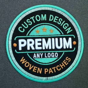 Puede incluir: Un parche bordado circular con fondo negro y borde verde azulado. El texto dice CUSTOM DESIGN, PREMIUM, ANY LOGO y WOVEN PATCHES en blanco, verde azulado y naranja. Tres pequeñas estrellas naranjas están centradas sobre la palabra PREMIUM.