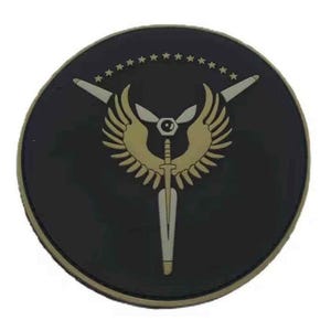 May include: A circular black patch featuring a central gold emblem of a winged sword and a propeller. Above the emblem, a horizontal arc of thirteen small gold stars is displayed. The design is rendered in a flat, matte finish with a raised texture.