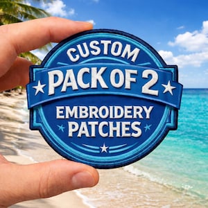 May include: A circular embroidered patch featuring a dark blue background with light blue circular borders. The text reads CUSTOM PACK OF 2 EMBROIDERY PATCHES in white capital letters, accented by small white stars and horizontal lines.