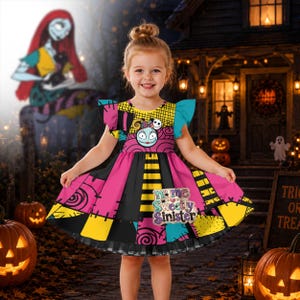 May include: A short-sleeved dress featuring a patchwork pattern of pink, yellow, and blue sections with black stitch details. The bodice displays a character face, and the skirt includes the text name Sweetly Sinister in a decorative font.