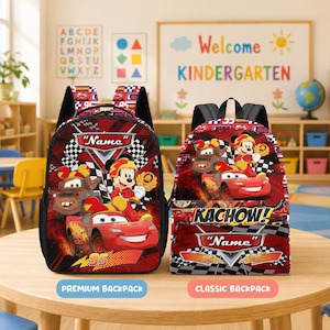 Peut inclure: Deux sacs à dos rouges avec des graphismes de Disney Cars et Mickey Mouse. Le sac de gauche affiche le texte Name, tandis que celui de droite présente le texte Kachow! et Name, avec des motifs de damier et le numéro 95 sur les deux articles.