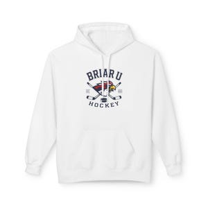 Op de afbeelding: Een witte hoodie met een centrale afbeelding en de tekst BRIAR U HOCKEY. Het ontwerp bevat een gestileerd vogelkop-logo, twee gekruiste hockeysticks, een puck en de tekst EST. 2025. De trui heeft lange mouwen en een voorzak aan de voorzijde.