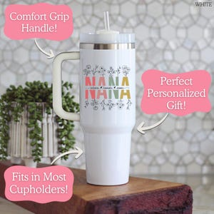 May include: A white stainless steel tumbler with a handle and a clear straw. The tumbler features a floral design with the word NANA in colorful block letters and three names printed in a script font between the floral elements.