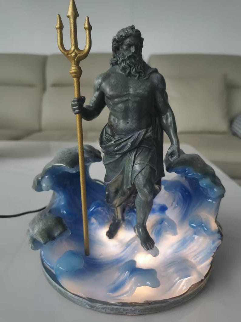 K&ouml;nnte beinhalten: Eine Statue von Poseidon, dem griechischen Gott des Meeres, der einen goldenen Dreizack h&auml;lt. Die Statue ist dunkelgrau und steht auf einem Sockel aus blauen und wei&szlig;en Wellen. Der Sockel wird von einem sanften Licht beleuchtet.