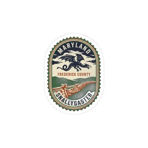 Könnte beinhalten: Ovaler Aufkleber mit einem Drachen, den Worten "Maryland" und "Frederick County". Der Aufkleber hat einen grünen und braunen Rand mit dem Wort "Snallygaster" unten. Das Design umfasst einen Zaun und eine Landschaft.