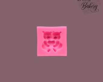 May include: Pink silicone mold with a design of two bears hugging each other.