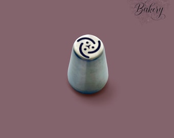 May include: A silver metal piping nozzle with a conical shape and a flat top featuring a cut-out design of three curved lines and three small dots. The text My Little Bakery is printed in the upper right corner in a dark script font.