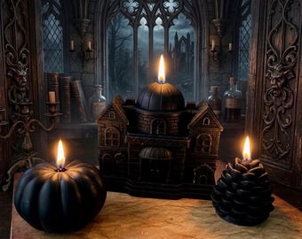 May include: Three black candles with lit flames. One candle is shaped like a pumpkin, one like a building with a central dome, and one like a pinecone. The candles are arranged on a textured surface in front of a dark, gothic-style window.