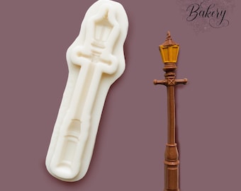 May include: A white silicone mold shaped like a street lamp next to a finished brown street lamp figure with a yellow light section. The text My Little Bakery is visible in the upper right corner of the image, representing the brand identity.