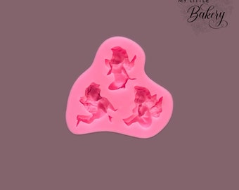 May include: Pink silicone mold with three angel shapes. The mold is designed for making fondant or gum paste decorations.