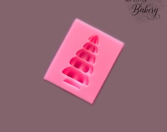 May include: Pink silicone mould with a single, raised, tree-shaped design. The tree has a rounded, pointed top and five tiers.