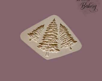 May include: A silicone mould with three detailed Christmas tree designs. The mould is white and the trees are a light brown colour.