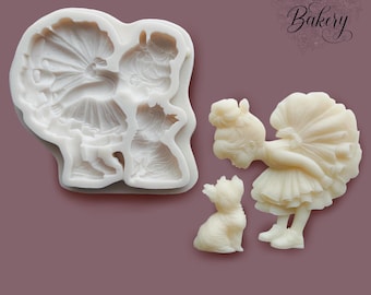 May include: A white silicone mold and two off-white resin figures, one of a small dog and one of a girl in a ruffled dress. The mold features recessed cavities for casting these shapes. The text My Little Bakery is visible in the upper right corner.