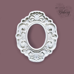 Puede incluir: Molde de plástico blanco de un marco ovalado adornado con un diseño en relieve. El molde se utiliza para hornear y decorar pasteles.