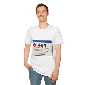 Könnte beinhalten: Ein weißes kurzärmeliges T-Shirt mit einer Grafik eines Computer-Fehlermeldungsfensters. Das Fenster hat eine blaue Titelleiste, ein rotes X-Symbol und den Text 404 Costume Not Found. Die Nachricht lautet The requested costume does not exist. Please try again next year.