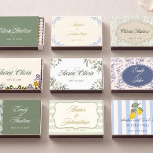 K&ouml;nnte beinhalten: Neun rechteckige Streichholzschachteln in einem Raster angeordnet, jede mit einzigartigen Designs mit Namen wie Olivia und Andrew, Amber und Johnathan, Aaron und Olivia, Emily und John sowie Amber und Zack's Wedding, zusammen mit Daten und Blumen- oder Streifenmustern.