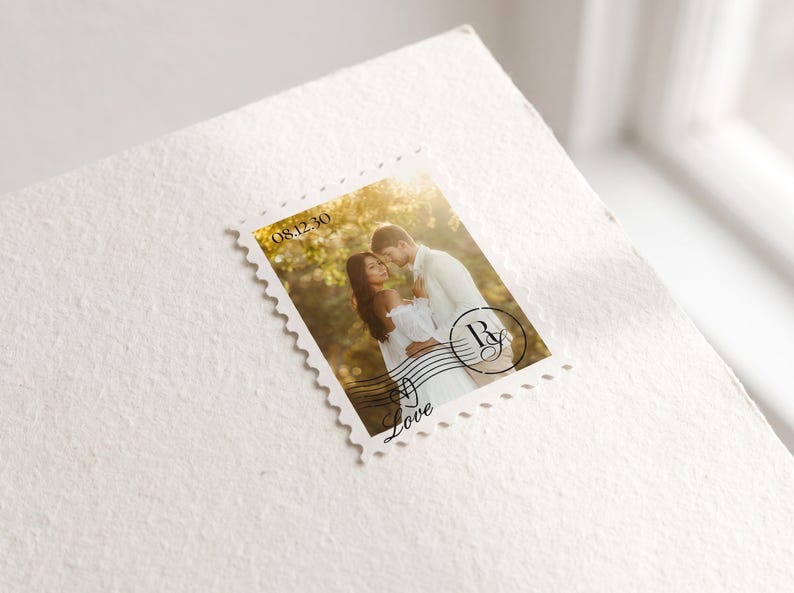 K&ouml;nnte beinhalten: Eine rechteckige Briefmarke mit einem Foto eines Paares in einer Au&szlig;enumgebung. Die Briefmarke enth&auml;lt das Datum 08.12.30, ein kreisf&ouml;rmiges Monogramm mit den Buchstaben R und G sowie das Wort Love in einer kursiven Schriftart.