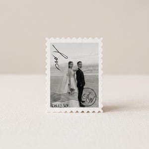 K&ouml;nnte beinhalten: Eine rechteckige Briefmarke mit einem Schwarz-Wei&szlig;-Foto eines Paares am Strand. Die Briefmarke enth&auml;lt das Wort Love in Schreibschrift, das Datum 08.12.30 und ein kreisf&ouml;rmiges Monogramm mit den Buchstaben JW, alles umgeben von einem gezackten Rand.