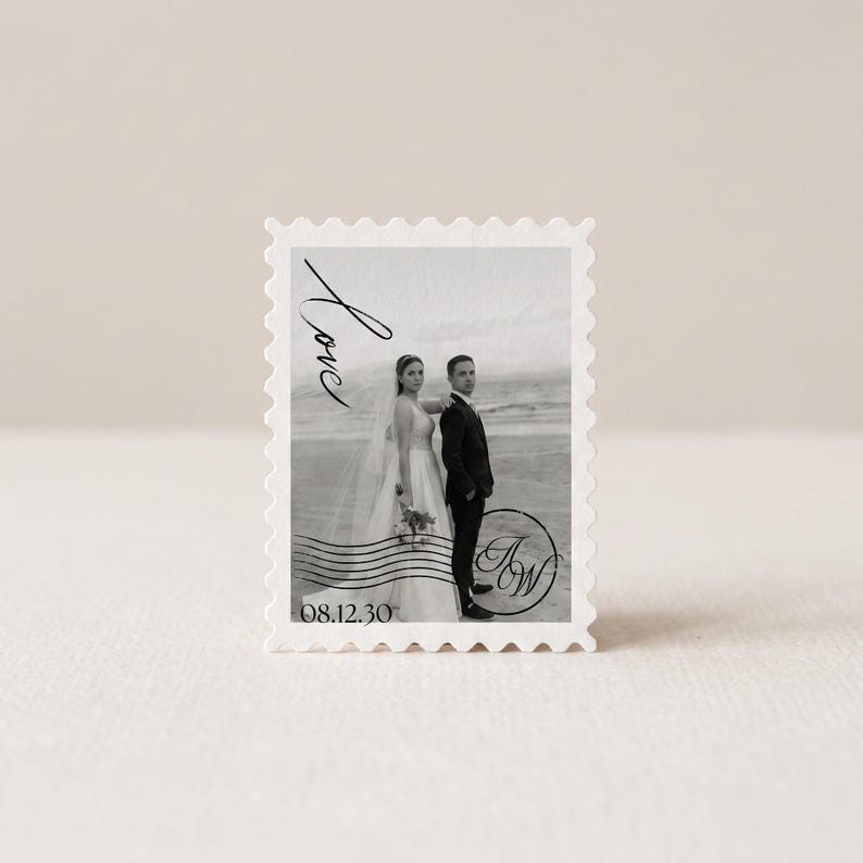 K&ouml;nnte beinhalten: Eine rechteckige Briefmarke mit einem Schwarz-Wei&szlig;-Foto eines Paares am Strand. Die Briefmarke enth&auml;lt das Wort Love in Schreibschrift, das Datum 08.12.30 und ein kreisf&ouml;rmiges Monogramm mit den Buchstaben JW, alles umgeben von einem gezackten Rand.