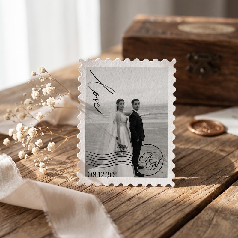 K&ouml;nnte beinhalten: Eine rechteckige Karte im Briefmarkenstil mit einem Schwarz-Wei&szlig;-Foto eines Paares am Strand. Die Karte enth&auml;lt den kursiven Text Love, das Datum 08.12.30 und ein kreisf&ouml;rmiges Monogramm mit den Buchstaben AW.