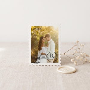 K&ouml;nnte beinhalten: Eine rechteckige Briefmarke mit einem Foto eines Paares, das sich in einer sonnigen Au&szlig;enumgebung umarmt. Die Briefmarke enth&auml;lt das Datum 08.12.30, ein kreisf&ouml;rmiges Monogramm mit den Buchstaben R und Y sowie das Wort Love in schwarzer Schrift.
