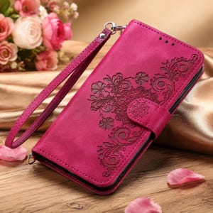 Peut inclure: Un étui de téléphone portefeuille magenta avec un motif floral mandala en relief sur la couverture avant. L'étui comprend une dragonne assortie détachable et une languette de fermeture magnétique pour sécuriser l'appareil mobile.