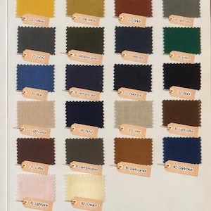 May include: A color swatch chart featuring twenty-two rectangular fabric samples with pinked edges. Each sample is labeled with a numbered tan tag, including colors like yellow, brick, gray, green, blue, navy, coffee, light pink, and cream.