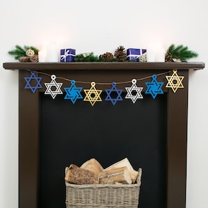 Large star of david garland with 8 stars strung across dark wood mantelpiece. Stars are gold, electric blue, white or navy blue.