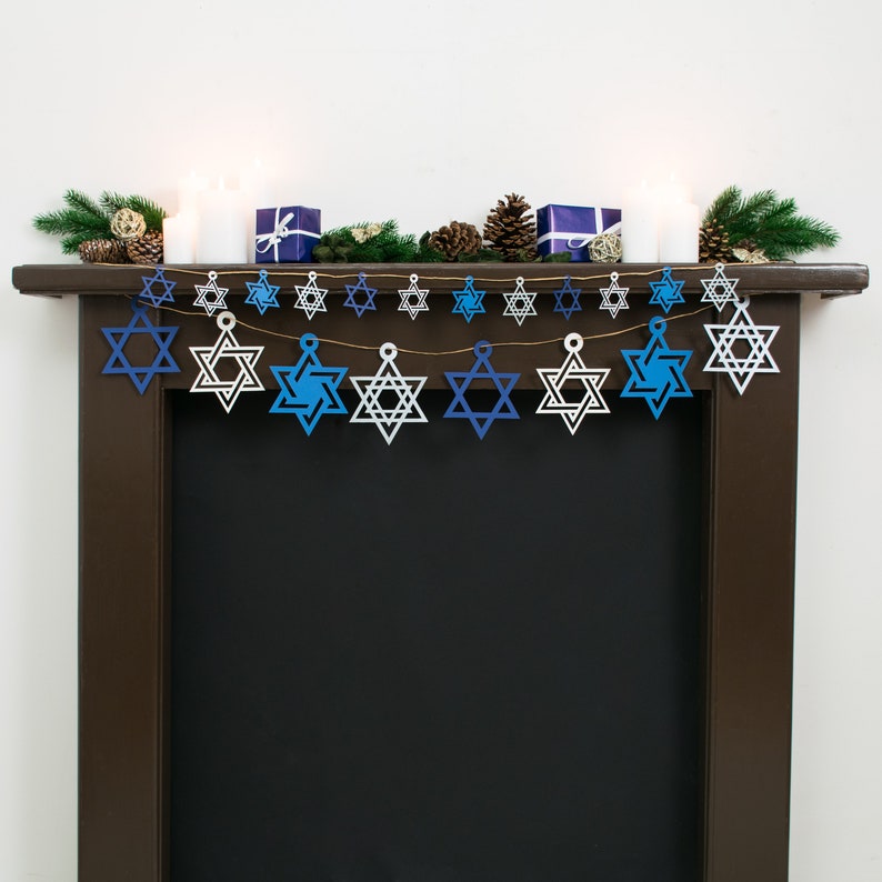 Large and small sized star of david garlands displayed together strung across a dark wood mantelpiece.  Stars are electric blue, white, navy blue and silver