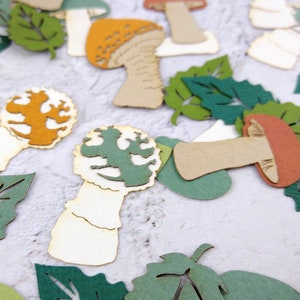 May include: Assortment of paper craft cutouts featuring mushrooms and leaves in various shades of green, brown, orange, and white.
