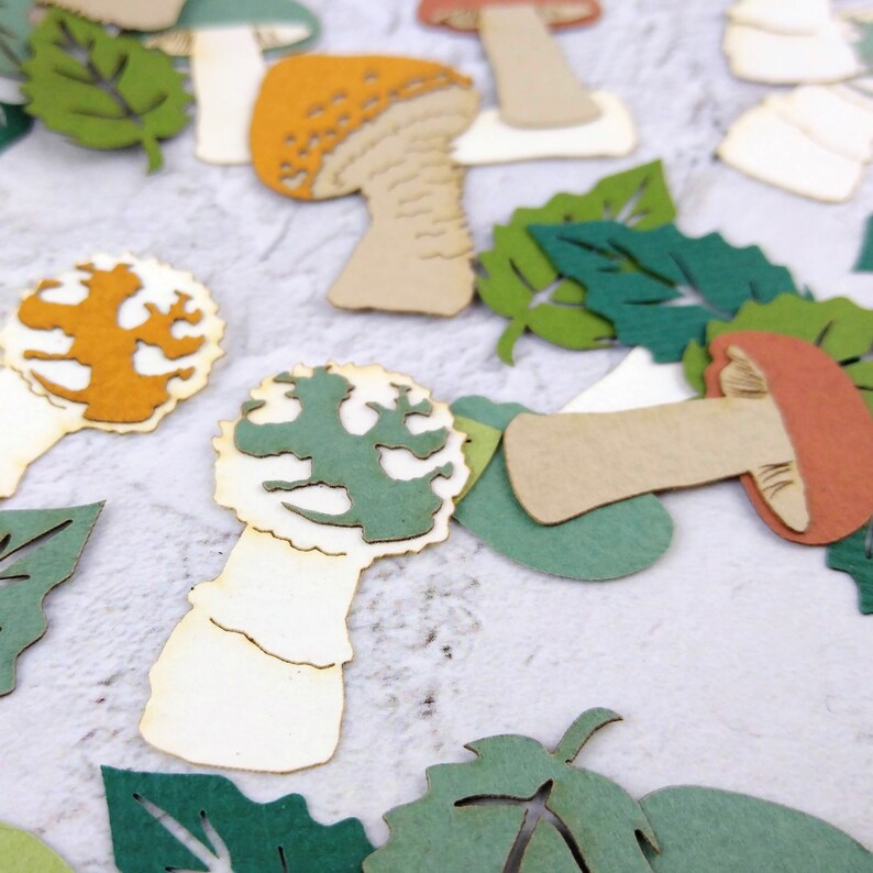 May include: Assortment of paper craft cutouts featuring mushrooms and leaves in various shades of green, brown, orange, and white.