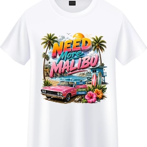 May include: A white t-shirt featuring a graphic print of a pink convertible car on a beach with palm trees, a lifeguard tower, surfboards, and hibiscus flowers. The text reads NEED More MALIBU with a sign listing SUN, SALT, GOOD VIBES, MALIBU.