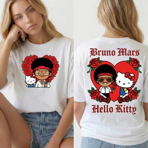 May include: White t-shirt featuring a cartoon illustration of Bruno Mars and Hello Kitty inside a heart-shaped design with roses. The front of the shirt shows the characters, while the back displays the text "Bruno Mars Hello Kitty".