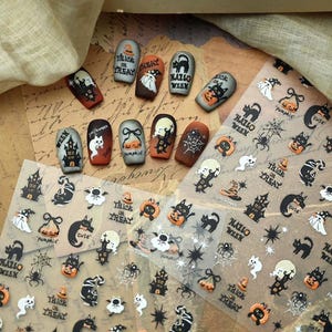 May include: A collection of Halloween-themed nail art stickers featuring black cats, pumpkins, haunted houses, ghosts, and spider webs, alongside ten press-on nails decorated with similar motifs and the text Trick or Treat and Halloween.