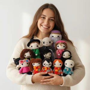 Puede incluir: Una colección de muñecos de ganchillo hechos a mano, con personajes con rasgos distintivos. Los muñecos tienen varios colores de pelo, atuendos y accesorios. Algunos muñecos llevan bufandas, sombreros y gafas. Los muñecos son sostenidos por una persona.