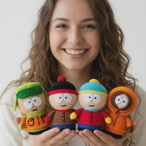 May include: Four crocheted dolls, each representing a character from a popular animated series. The dolls feature distinct outfits and facial expressions, with vibrant colors like orange, green, red, and blue. The dolls are held in front of a smiling person.