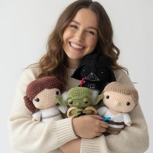 Könnte beinhalten: Eine Sammlung gehäkelter Star Wars-Charakterpuppen, darunter Darth Vader, Yoda, Prinzessin Leia und Luke Skywalker. Die Puppen sind handgefertigt mit detaillierten Merkmalen und verschiedenen Farben, die einen skurrilen und künstlerischen Stil zeigen.