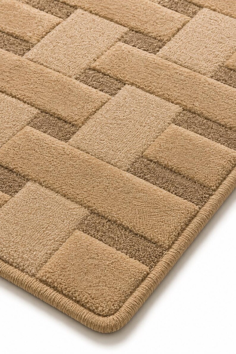 Peut inclure: Un tapis rectangulaire pr&eacute;sentant un motif tiss&eacute; compos&eacute; de carr&eacute;s touffet&eacute;s alternant entre le beige clair et le brun moyen. Le tapis poss&egrave;de un bord fini et surjet&eacute; avec un fil beige assorti, cr&eacute;ant une surface textur&eacute;e et uniforme.