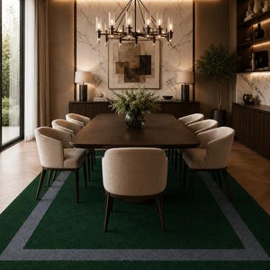 May include: A rectangular area rug featuring a deep forest green center bordered by a thick charcoal gray frame. The rug is positioned beneath a dark wood dining table surrounded by eight upholstered beige chairs with dark wooden legs.