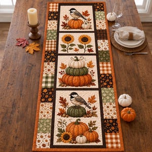 Peut inclure: Un chemin de table matelassé rectangulaire avec une bordure en patchwork de tissus aux motifs automnaux. Les panneaux centraux présentent des illustrations de mésanges, de tournesols et de citrouilles empilées dans des tons orange, vert et crème.