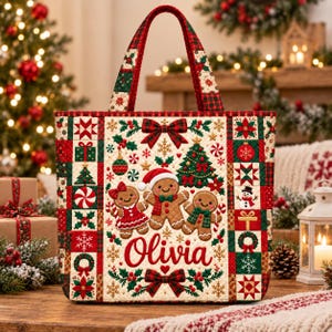 May include: A quilted tote bag featuring a festive Christmas pattern with gingerbread characters, a decorated tree, and the name Olivia printed in red script. The design includes red and green plaid borders, snowflakes, and holiday motifs.