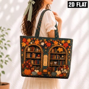 Può includere: Una borsa tote verde scuro con una stampa di due librerie ad arco piene di libri colorati, foglie autunnali e zucche. Un cartello centrale recita: Autumn stories, warm hearts & cozy pages. La borsa è dotata di due spallacci coordinati.