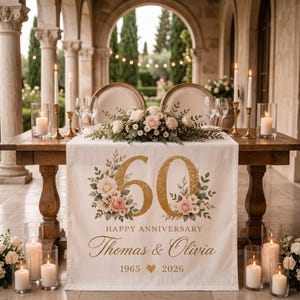May include: A white table runner featuring a large gold glitter number 60, floral accents, and the text Happy Anniversary Thomas & Olivia 1965 2026. The runner is displayed on a wooden table with candles, wine glasses, and a floral centerpiece.