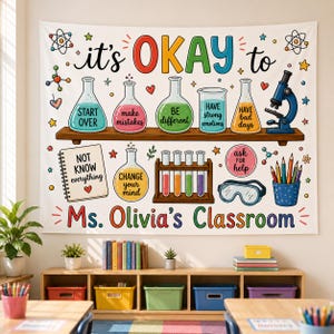 May include: A white wall tapestry featuring colorful science-themed illustrations including beakers, a microscope, test tubes, and safety goggles. The text reads: it's OKAY to START OVER, make mistakes, BE different, HAVE strong emotions, HAVE bad days, NOT KNOW everything, CHANGE your mind, ask for help, and Ms. Olivia's Classroom.