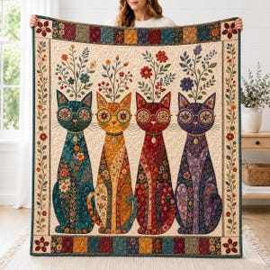 May include: A rectangular quilt featuring four stylised cats in teal, yellow, red, and purple, each wearing round glasses and adorned with floral patterns. Each cat has a bouquet of flowers emerging from its head, framed by a decorative floral border.